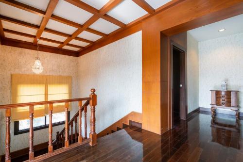 a room with a staircase and a ceiling with wood at Orchid Pool Villa Phuket - SHA Extra Plus in Phuket Town