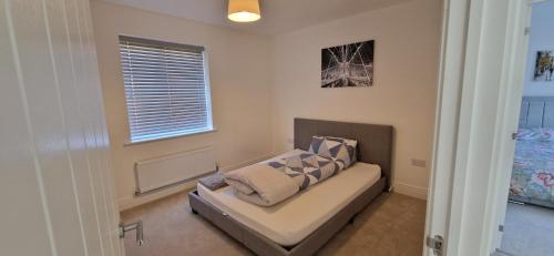 a living room with a couch and a window at Brand new Entire 4-Bed House in Peterborough in Peterborough