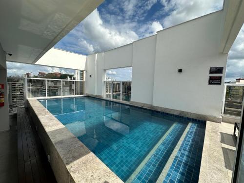 a swimming pool on the roof of a building at Studio Felicittá piscina cozinha academia in Juiz de Fora