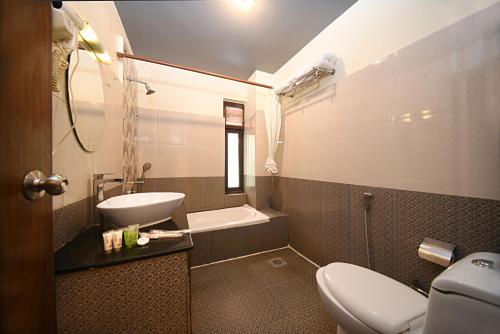 a bathroom with a toilet and a sink and a tub at Hotel Amaryllis Kathmandu in Kathmandu