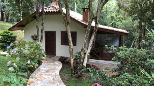 a house with a stone walkway in front of it at Chalés Recanto das Montanhas in Monte Verde