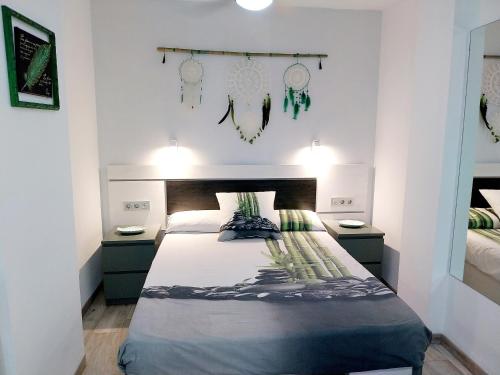ein Schlafzimmer mit einem Bett und zwei Nachttischen in der Unterkunft SOL & MAR Playa de las vistas Torres del Sol A504 in Arona