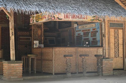 ein Restaurant mit einer Bar mit Strohdach in der Unterkunft Bunga Jabe in Karimunjawa