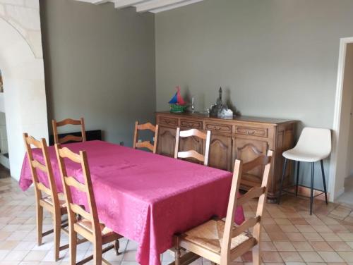 comedor con mesa y sillas rosas en Le moulin neuf, en Saint-Nicolas-de-Bourgueil