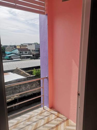 a room with a balcony with a view of a building at Homie in Ban Tha Kham