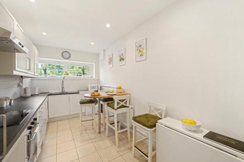 a kitchen with a table and chairs in it at 3 Bedroom Mews Home - Clapham Common - Free Private Parking - Sleeps 5 - Newly Refurbished - Sweetpea & Pillow Properties in London