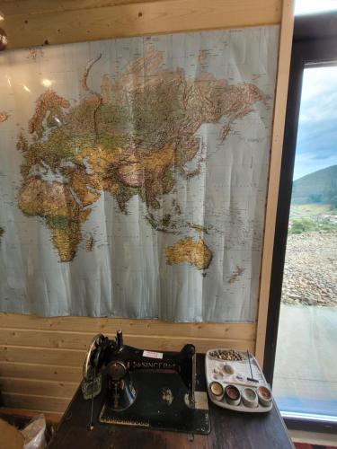 a map of the world on a wall next to a sewing machine at Cucu Zen Cazare Cabane Pensiuni Bucovina in Iacobeni