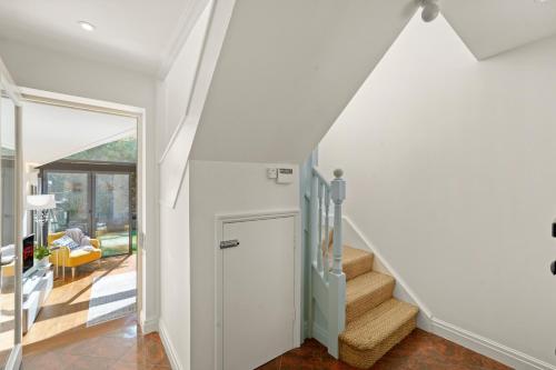 a staircase in a house with white walls at 3 Bedroom Mews Home - Clapham Common - Free Private Parking - Sleeps 5 - Newly Refurbished - Sweetpea & Pillow Properties in London