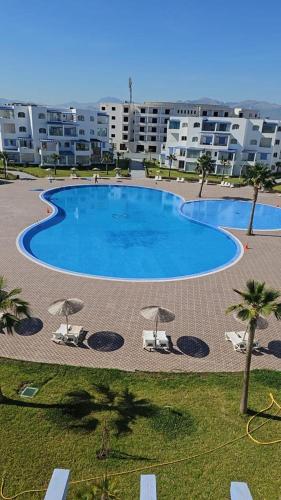una grande piscina con sedie e ombrelloni di Luxury resident with pool a Cabo Negro