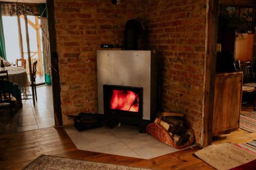 a fireplace in a living room with a brick wall at Osmolicka Chatka in Ryki