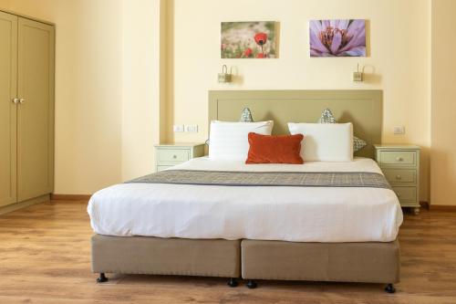 a bedroom with a large bed with two pillows at Yehelim Boutique Hotel in Arad