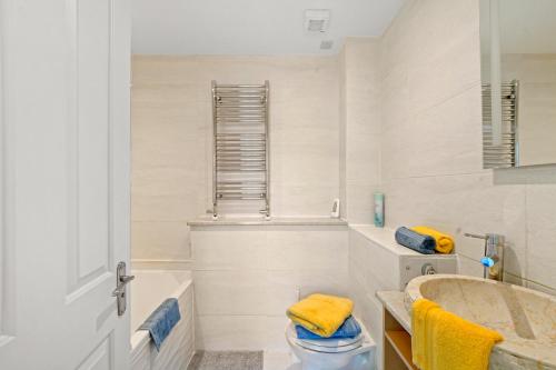 a bathroom with a tub and a toilet and a sink at 3 Bedroom Mews Home - Clapham Common - Free Private Parking - Sleeps 5 - Newly Refurbished - Sweetpea & Pillow Properties in London