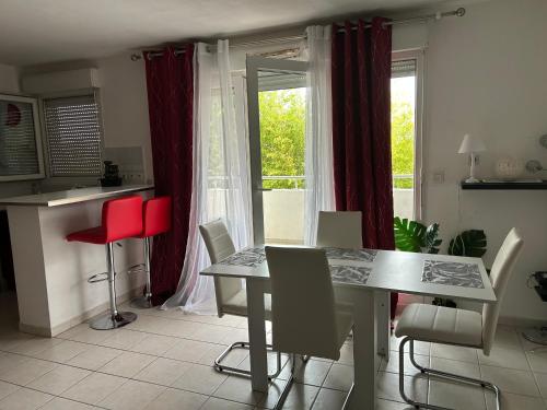 une salle à manger avec une table et des chaises et une fenêtre dans l'établissement APPT MONTPELLIER 2 CHAMBRES et 10 minutes des Plages, à Montpellier