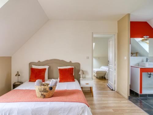a bedroom with a bed with red pillows and a sink at Villa MY le Mans in Saint-Saturnin