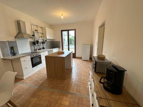 a kitchen with a island in the middle of a room at Maison paisible, 15 min du Futuroscope & Arena. in Fontaine-le-Comte