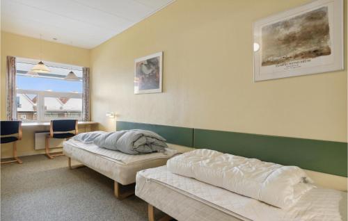Habitación con 2 camas, mesa y escritorio. en Fan Bad, Lejl, 105, en Fanø