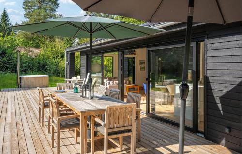 a wooden table with an umbrella on a deck at 3 Bedroom Amazing Home In Silkeborg in Silkeborg