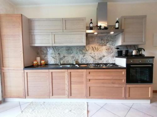 a kitchen with wooden cabinets and a sink at La casa di Sara in Valsassina in Introbio