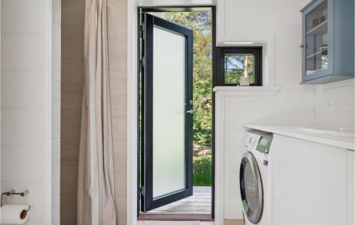 3 Bedroom Awesome Home In Silkeborg في سيلكبورج: حمام مع نافذة وغسالة ملابس