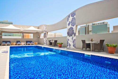 una grande piscina con acqua blu in un edificio di Oaks Liwa Executive Suites a Abu Dhabi