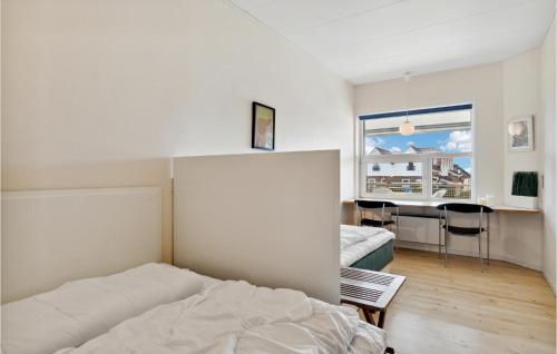 Schlafzimmer mit einem Bett, einem Tisch und einem Fenster in der Unterkunft Fan Bad, Lejl, 109 in Fanø