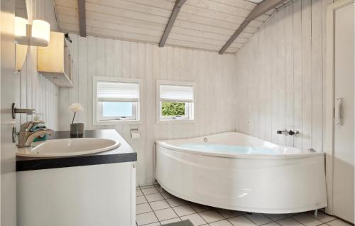 ein weißes Badezimmer mit einer großen Badewanne und einem Waschbecken in der Unterkunft Awesome Home In Bjert With Wifi in Binderup Strand