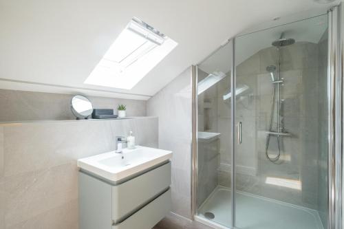 La salle de bains est pourvue d'un lavabo et d'une douche. dans l'établissement Avocet Cottage, à Aldeburgh