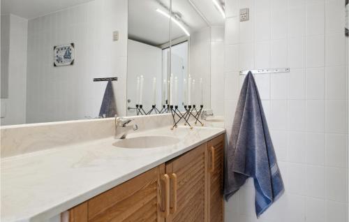uma casa de banho com um lavatório e uma toalha azul em Fan Bad, Lejl, 75 em Fanø