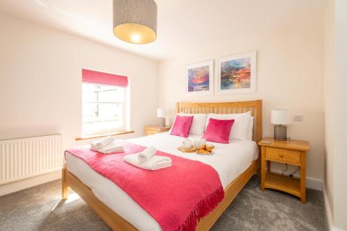 - une chambre avec un grand lit et une couverture rouge dans l'établissement Avocet Cottage, à Aldeburgh