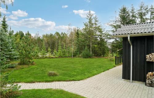 a yard with a black building and a green lawn at Nice Home In Thyholm With Wifi in Thyholm