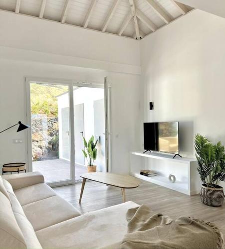 een woonkamer met een witte bank en een tv bij LA GRAMA V, comodidad y excelente ubicación in Breña Alta
