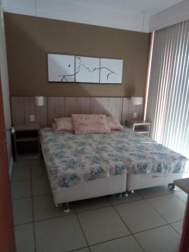 a bedroom with a large bed with a blue comforter at Flat_Quartie_aldeia_das_aguas in Barra do Piraí