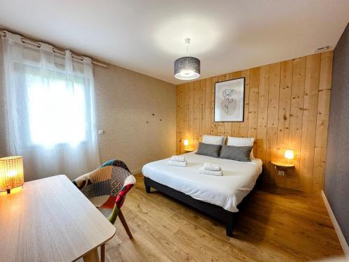 a bedroom with a bed and a table and a window at Gites-domainedupin, cottage "Mosnes à Lisa" in Mosnes