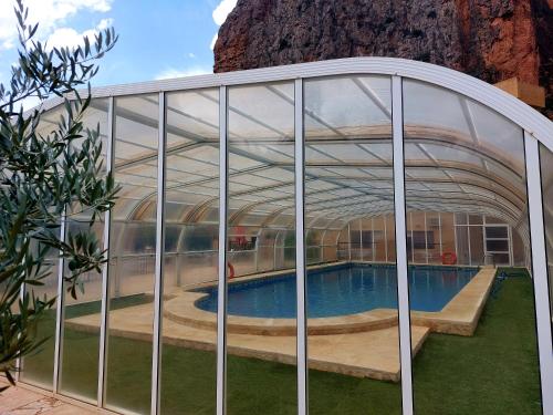 a glass house with a swimming pool inside at Hotel Restaurante Felipe II in Ayna