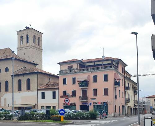 a building with a clock tower and a church at AL PONTE design apartment in Conegliano