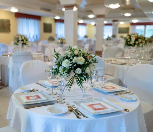 a dining room with white tables and white chairs at Yellow Park Hotel in Forchia