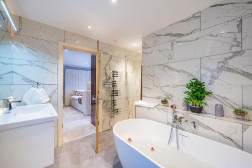 a bathroom with a bath tub and a sink at *RD7C* For your most relaxed & Cosy stay + Free Parking + Free Fast WiFi * in Batley