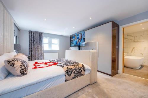 een slaapkamer met een groot bed en een badkamer bij *RD7C* For your most relaxed & Cosy stay + Free Parking + Free Fast WiFi * in Batley