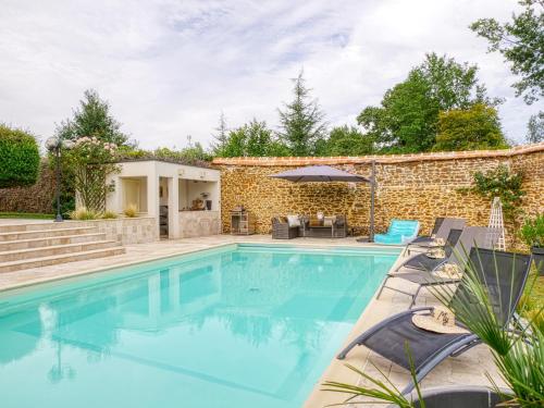 a swimming pool with a patio and a house at Villa MY le Mans in Saint-Saturnin