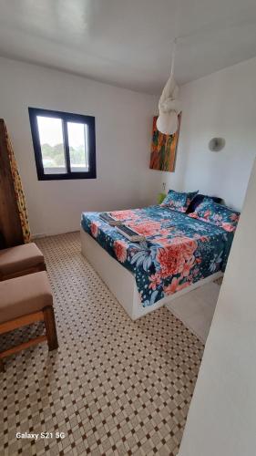 ein Schlafzimmer mit einem Bett und einem Stuhl in der Unterkunft Villa Les Pieux in Somone
