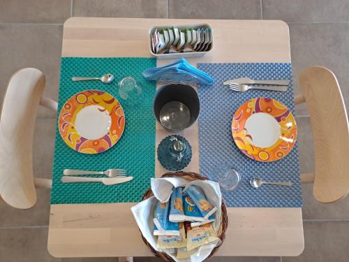 a wooden table with plates and utensils on it at La Campagna di Peppe e Tullia in Formia