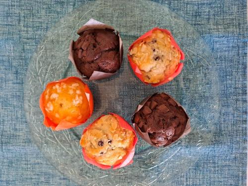 three chocolate muffins on a glass plate on a table at La Campagna di Peppe e Tullia in Formia