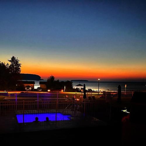 a sunset over the ocean and a swimming pool at The Water Street Inn in Ephraim