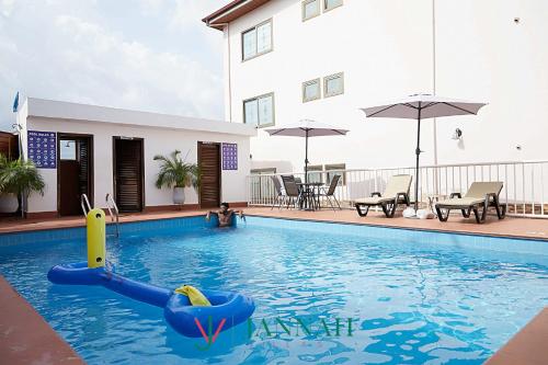 a child is playing in a swimming pool at JANNAH VILLAS - GHANA in Adentan