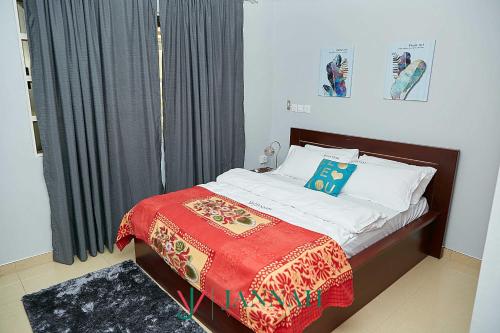 a bedroom with a bed with a red blanket at JANNAH VILLAS - GHANA in Adentan