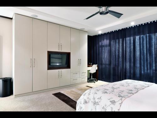 a bedroom with a bed and a tv in it at The Crystal 203 Camps bay - back-up power in Cape Town