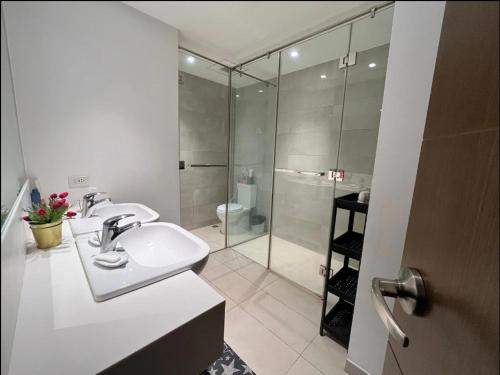 y baño con lavabo y ducha acristalada. en Modern and Comfortable Staycation - Unit 3718 Novotel Tower en Manila