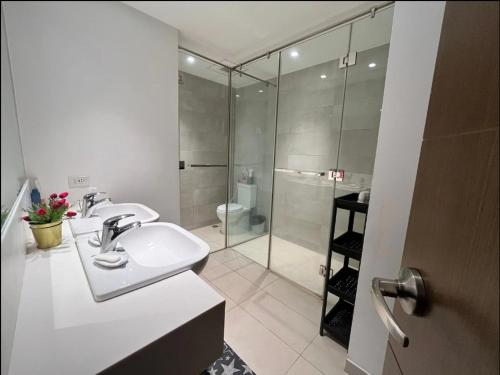 a bathroom with a sink and a glass shower at Modern and Comfortable Staycation - Unit 3718 Novotel Tower in Manila