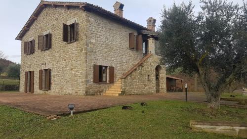 a large stone building with a tree in front of it at Villa Sant' Andrea in Gubbio
