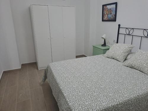 a bedroom with a bed and a green cabinet at Casa Tia Pilar in Algodonales